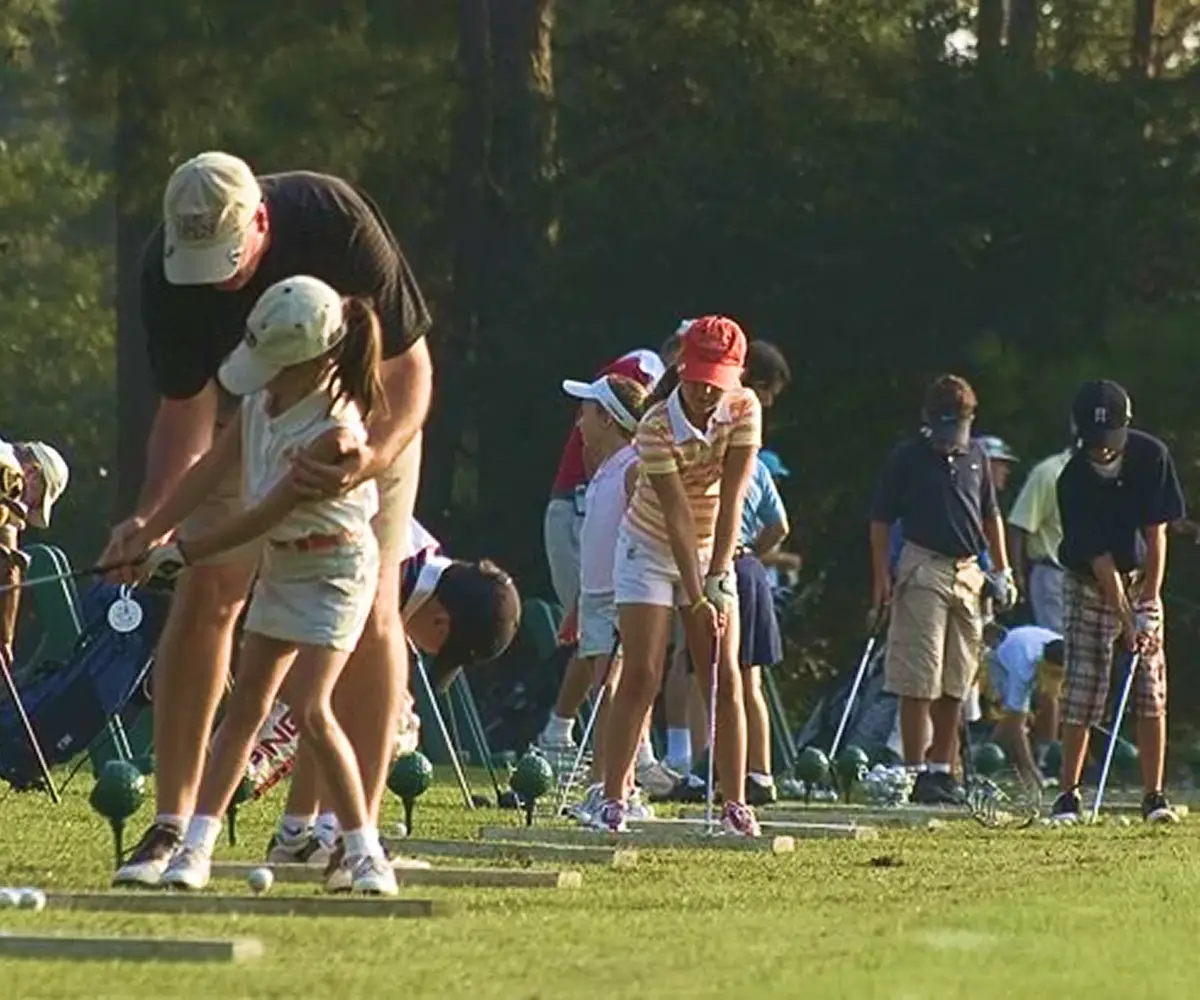 Group of golfers and instructors at driving range